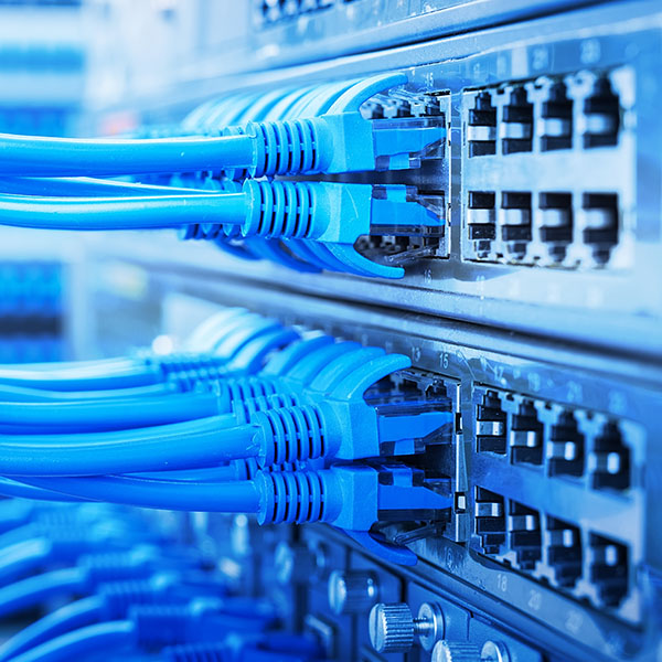 Cloud Storage - Blue network cables in the back of a rack of servers.