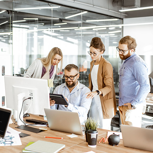 Managed WiFi - A group of professionals gather round a mobile device to conduct a work conversation.