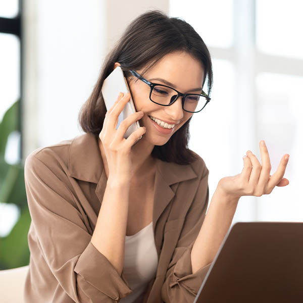 Business Mobile - A businesswoman at her desk talking on a mobile phone.