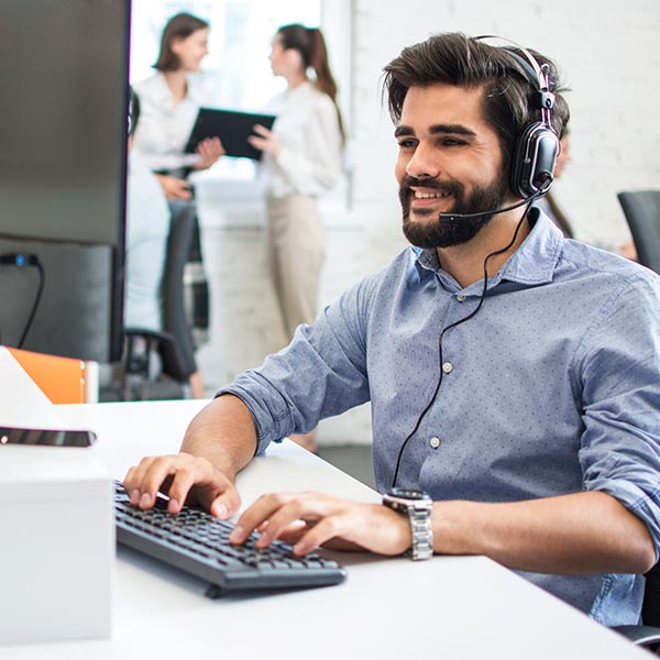 An IT support technician in the office taking a call from a customer.